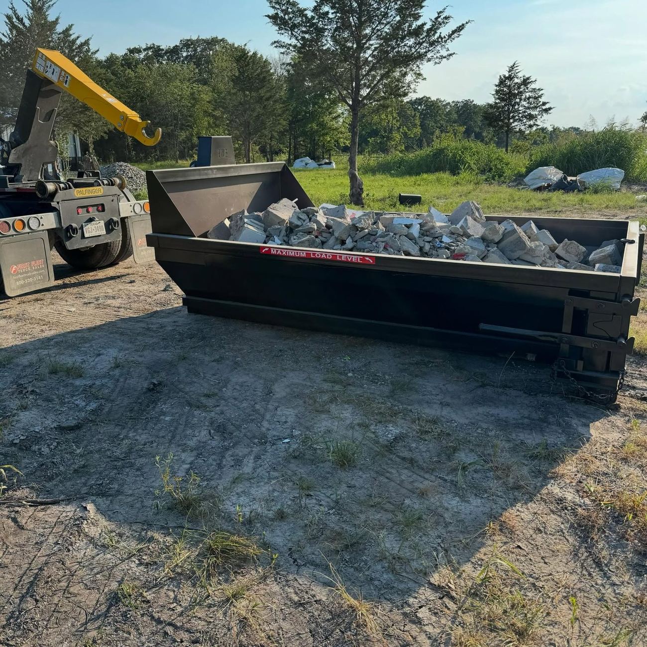 Regar concrete debris dumpster loaded with broken concrete
